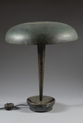 a green table lamp with a metal base and a black cord