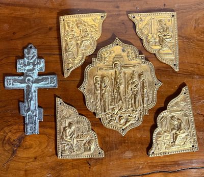 quatre morceaux de métal posés sur une table en bois, avec une croix et une croix