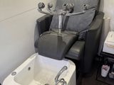 a reclining chair in the corner of a bathroom with a bathtub
