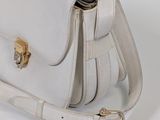 a white purse that is sitting on a white table