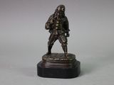 bronze statue of a man with a sword on a marble base