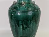 a green vase that has a picture of a elephant on it