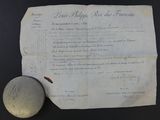 an old document with a stone next to it on a table