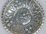 un plateau en argent orné de fleurs, posé sur une table