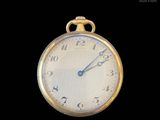 a close up of a gold pocket watch on a black background