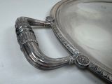 a silver plate with a handle on it on a table