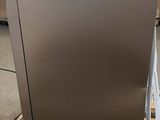 a silver refrigerator sitting on a pallet in a warehouse