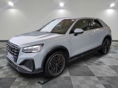 une Audi QX blanche de 2021 garée sur un sol à damier