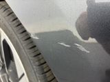 a cat that is sitting on the side of a car