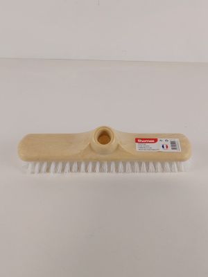 un gros plan d'une brosse en bois aux poils blancs posée sur une surface blanche