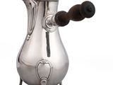 une cafetière ancienne en argent avec une poignée en bois sur fond blanc