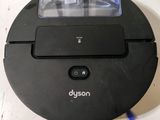 a close up of a black robotic vacuum cleaner on a white surface
