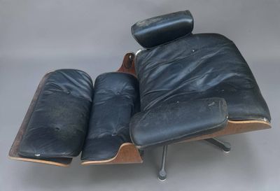 une image représentant un fauteuil et un repose-pieds en cuir noir sur fond blanc