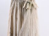 beige dress on a mannequin stand with flowers on it