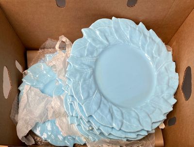 many plates in a box with plastic wrap around them