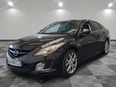 La Mazda noire est garée sur un sol en carrelage à damier.