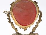 an image of a gold frame with a red stone in it