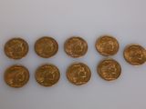 a group of six gold coins sitting on top of a white surface