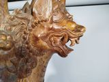 a wooden sculpture of a dragon on display in a room