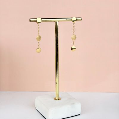 a gold plated earring stand with a pair of earrings hanging from it