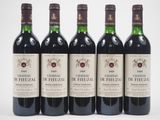 six bouteilles de vin sont alignées sur une surface blanche