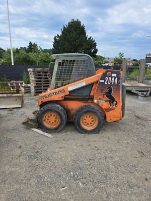 un petit ski orange – une porte – garé dans la terre