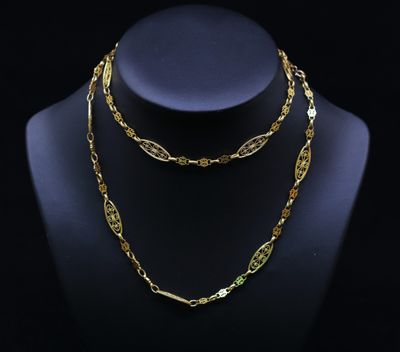 un ensemble composé d'un collier et d'un bracelet en or, présenté sur un mannequin