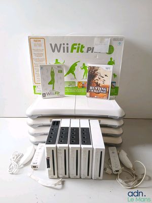 beaucoup de jeux Wii et de manettes posés sur la table