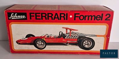 La boîte est ouverte pour montrer la maquette d'une Ferrari de Formule 1.