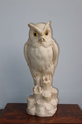 une statue représentant un hibou perché sur une table en bois