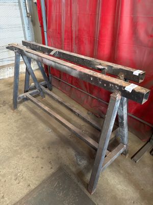 a large metal bench in a garage with a red curtain in the background