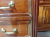 a wooden dresser with four drawers and a glass door