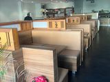des tables et des bancs dans un restaurant, avec une plante en pot