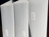 trois chemises blanches posées sur un bureau en bois, à côté d'une plante