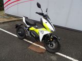 un scooter blanc et jaune garé sur un parking