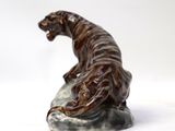 figurine of a tiger on a rock on a white background