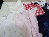 a lot of baby clothes that are laying on a table