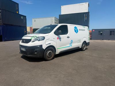 La camionnette est garée sur le parking à côté des conteneurs d'expédition.