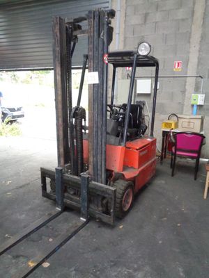 a red forklift truck parked in a garage