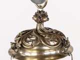 a metal bell with a bird on top of it
