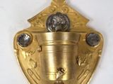 une assiette en or ornée d'une horloge, posée sur un fond blanc
