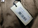a label on a fur coat that is on a hanger