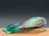 a glass sculpture of a snail on a wooden board