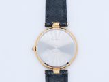 a close up of a watch on a white surface with a black strap