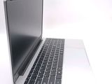 a silver laptop with a black keyboard on a white surface