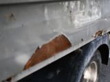 a close up of a truck with rust on the side