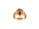a close up of a gold ring with a red stone