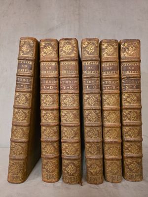 six vieux livres sont empilés sur une table
