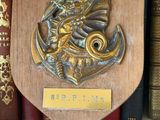 a plaque on a shelf with books on it