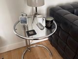 a glass table with a cell phone on it in a living room